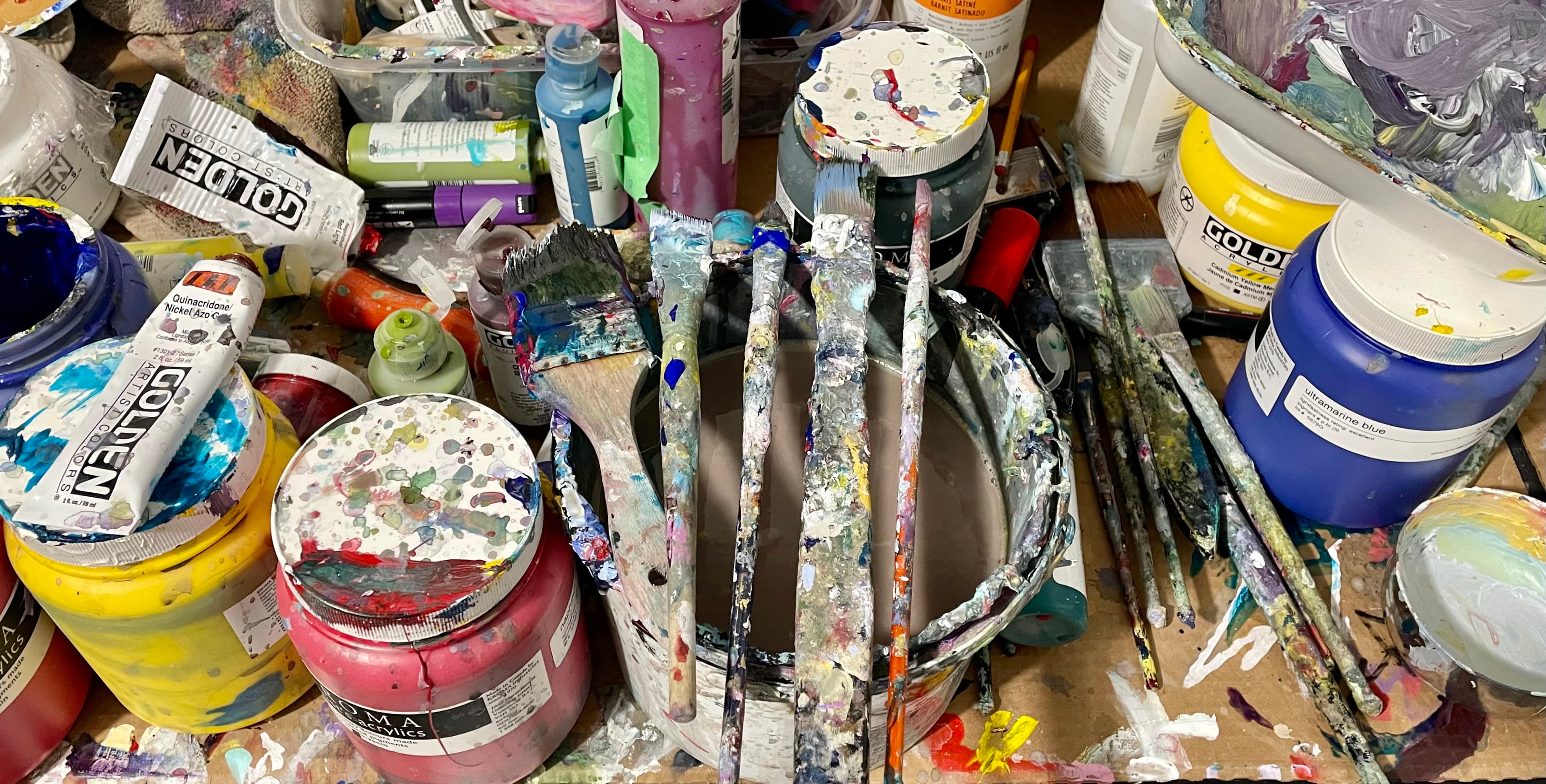 Andrew Lennon studio table with paint jars and brushes