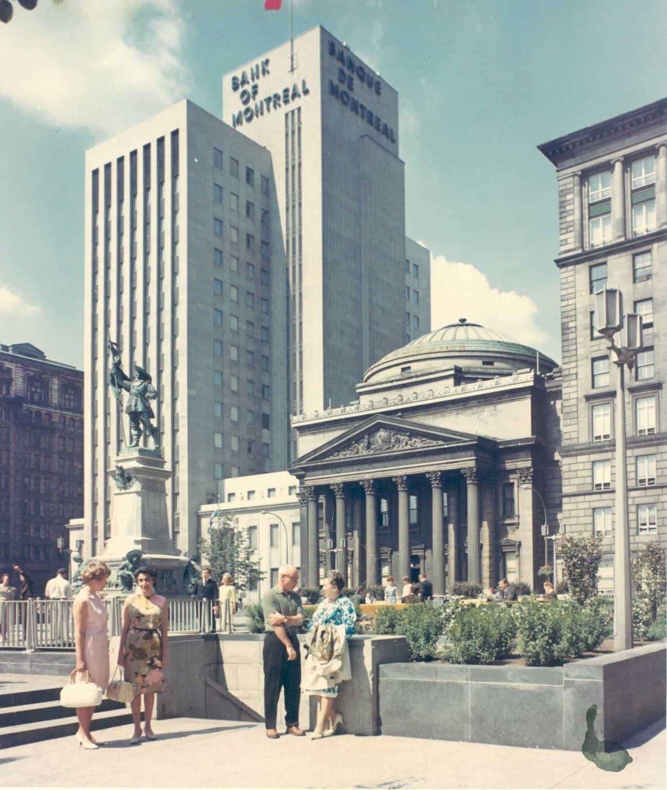 Color photograph of Place d’Armes with the Bank of Montreal tower, dome, and people in 1940s dress