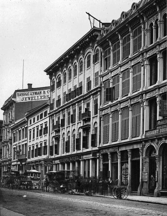 Archival street photograph showing the Ottawa Hotel, Savage Lyman jewellers, and horse-drawn carriages