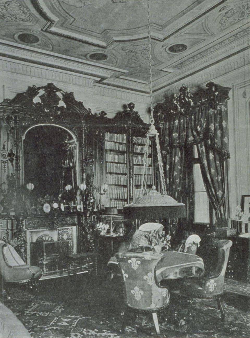 Ornate 19th-century library interior with carved wood, bookshelves, and Hilton-style furniture